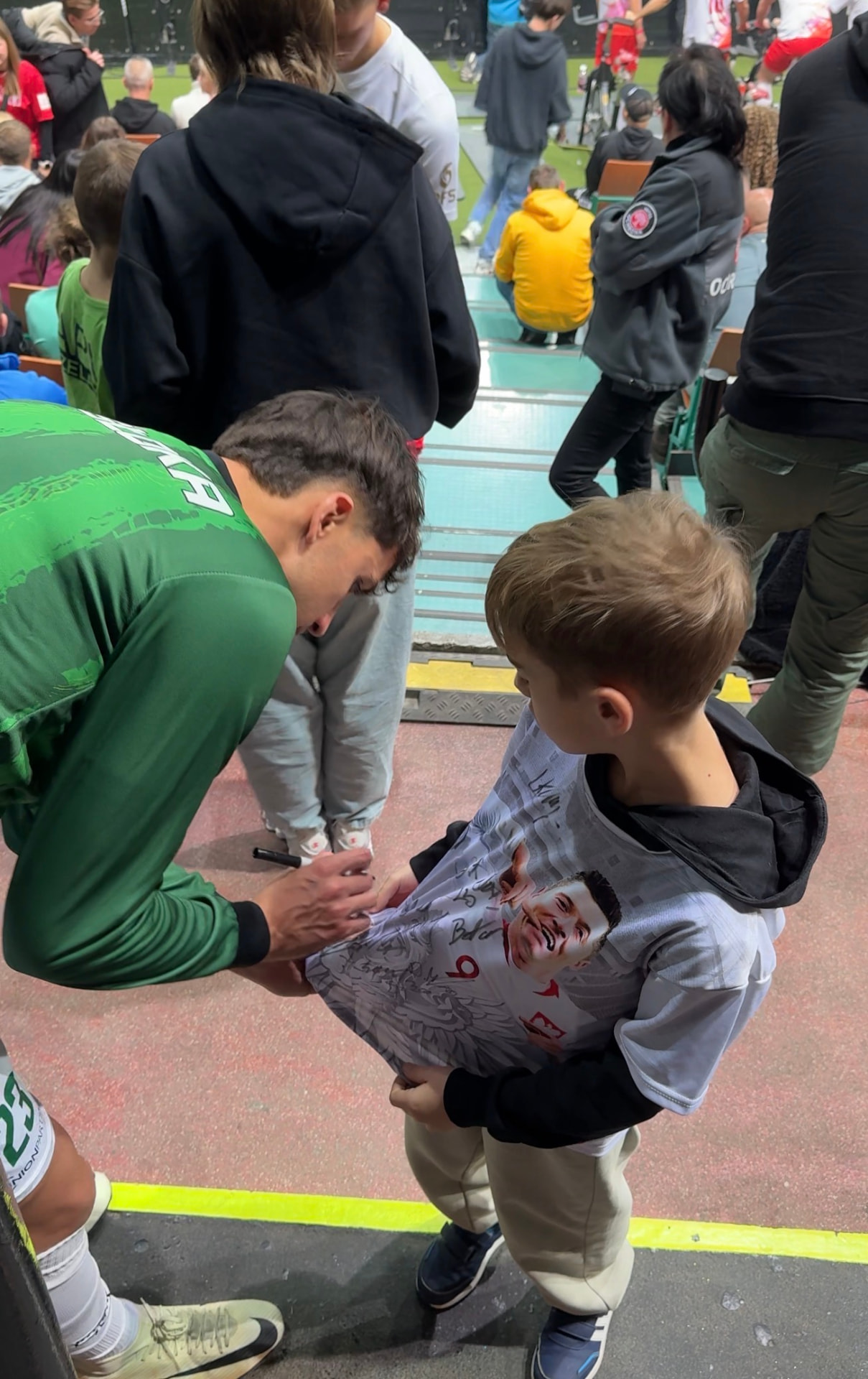 Signing an autograph for a young fan after a match
